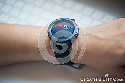 Smart watch at womanâ€™s hand checking heart rate at the office Stock Photo